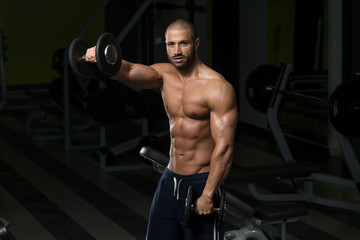 Plakat Bodybuilder Exercising Shoulders With Dumbbells