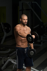 Naklejka na ściany i meble Male Bodybuilder Doing Heavy Weight Exercise For Shoulders