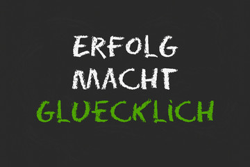 Erfolg macht Glücklich Schrift auf schwarzer Tafel