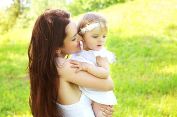Happy loving mom and baby together outdoors in sunny summer day