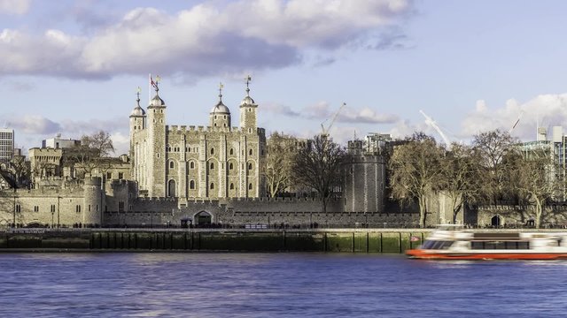 Timelapse view of the Tower of London on a cloudy late afternoon with boats cruising on the river Thames