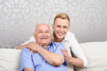 Grandson slightly embracing his grandfather
