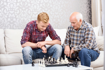 Grandfather and grandson playing chess 