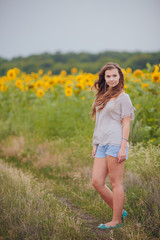 Naklejka na ściany i meble woman in beauty field with sunflowers