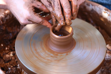 Hands working on pottery wheel