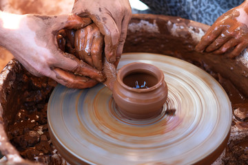 Hands working on pottery wheel