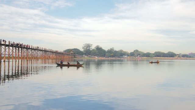 Fishermen on wooden fishing boats at morning near U-Bein bridge in Amarapura