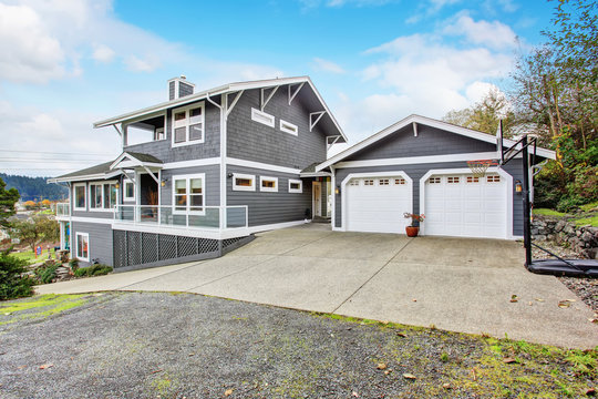 Large gray modern house and garage.