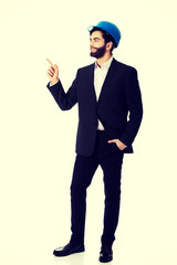 Engineer in protective helmet pointing up.