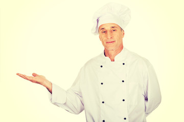 Mature chef showing copyspace on the left