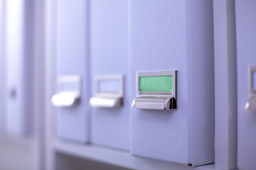 File folders, standing on shelves in the background