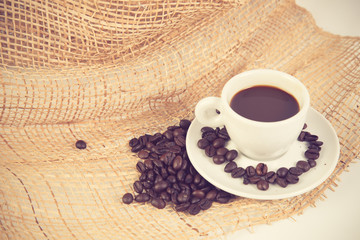 Coffee cup and beans on a white background vintage color