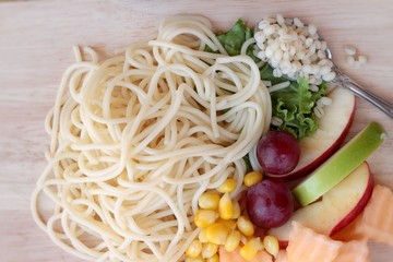 Pasta spaghetti with salad mix fruit.