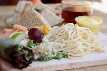 Pasta spaghetti with salad mix fruit and bread sandwich.