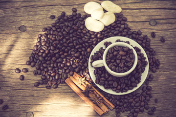 Coffee cup and coffee bean on a wooden table vintage color