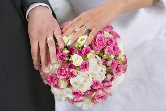 wedding rings, hand and flowers in the wedding photo
