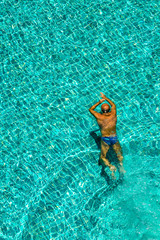 Relaxing in swimming pool./ Man swimming in the crystal-clear pool.
