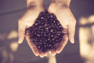 Coffee beans in hands vintage color