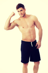 Fototapeta premium Young athletic man showing his muscles.