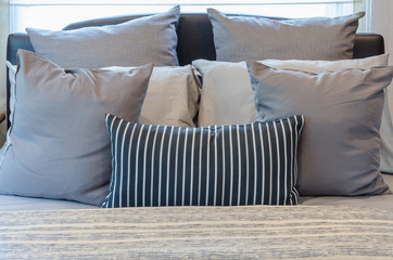 set of pillows on modern bed in bedroom