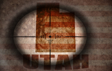 sniper scope aimed at the vintage american flag and utah state map
