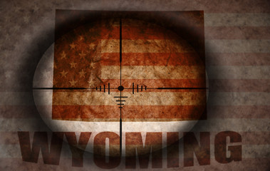 sniper scope aimed at the vintage american flag and wyoming state map