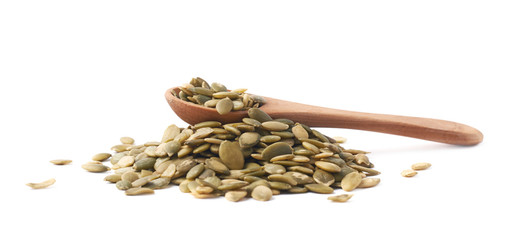 Wooden spoon over pumpkin seeds
