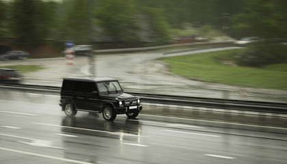 Black SUV travels fast on the highway.