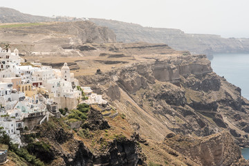 Fira in Santorini, seen from the edge of the cliffs, with a view of the Caldera in the background.