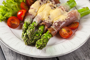 Baked green asparagus with prosciutto and cheese