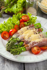 Baked green asparagus with prosciutto and cheese