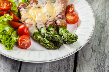 Baked green asparagus with prosciutto and cheese