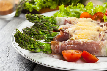 Baked green asparagus with prosciutto and cheese