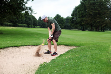 Golfer schlägt aus dem Sandbunker