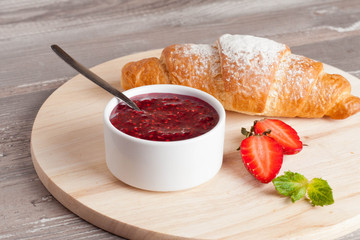 Strawberry jam with fresh fruits and fresh croissant
