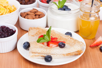 delicious breakfast - crepes with fresh berries and honey