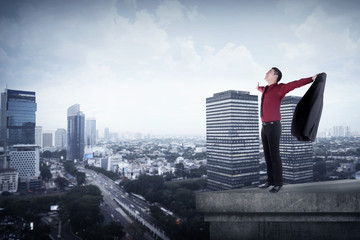Happy businessman standing on the rooftop