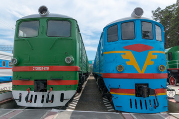 green and blue trains at station