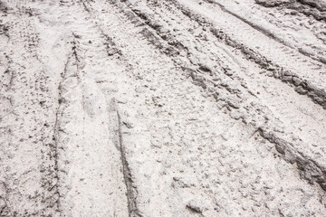 Dirty grunge tyre track on wet sand texture 