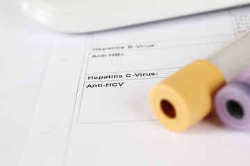 Laborzettel einer Hepatitis A, B und C Untersuchung und Blutröhrchen