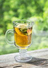 tea with mint and lemon in a glass mug