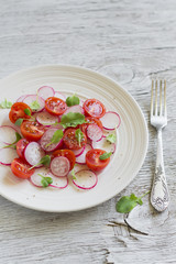 salad with cherry tomatoes and radishes in a white plate