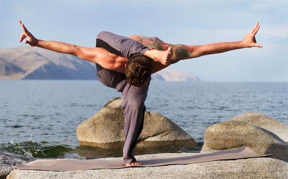 man practices yoga on the nature