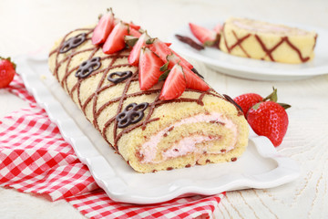 Homemade sponge roll with chocolate patterns, strawberries and cottage cheese cream