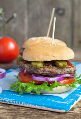 Homemade burgers with green salad, tomato, red onion, beef