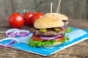 Homemade burgers with green salad, tomato, red onion, beef