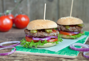 Homemade burgers with green salad, tomato, red onion, beef