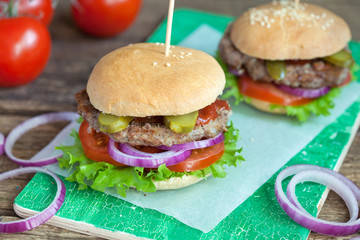 Homemade burgers with green salad, tomato, red onion, beef