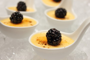 creme brulee desserts topped with fresh berries.