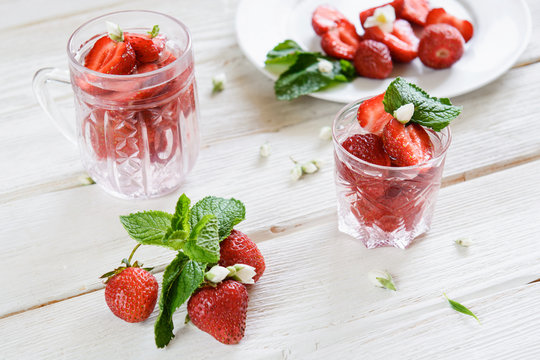 Fresh strawberry drink in glass on white wood background with mi